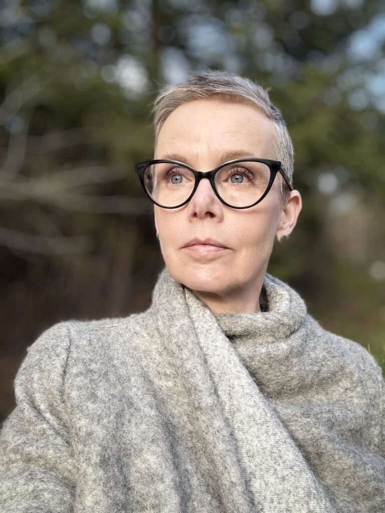Jennifer, founder of Digital Simplified, outdoors in a grey wrap, looking calm and focused